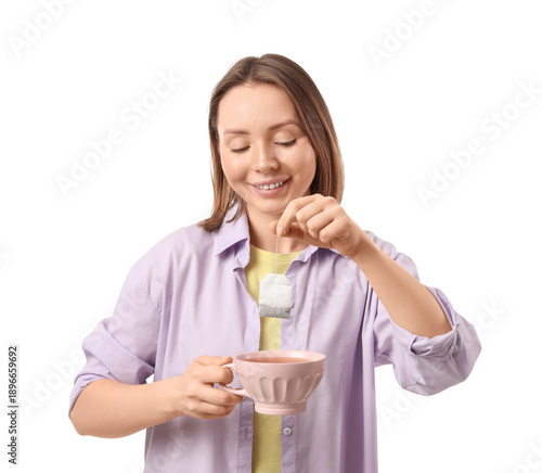 Young woman dipping tea bag into cup on white background