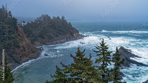 Foto Panorama of the foamy waters on a foggy afternoon at Cape Arago State Park near