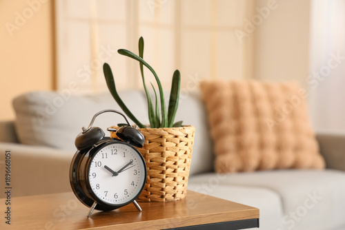 Φωτογραφία Alarm clock with plant on table at home