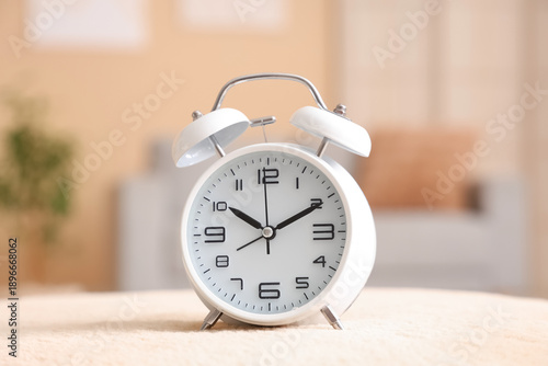 Photos Alarm clock on pouf at home