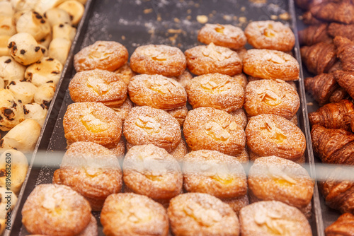 Lots of fresh cookies on trays in a store window. A delicious assortment of baked goods. Close-up.