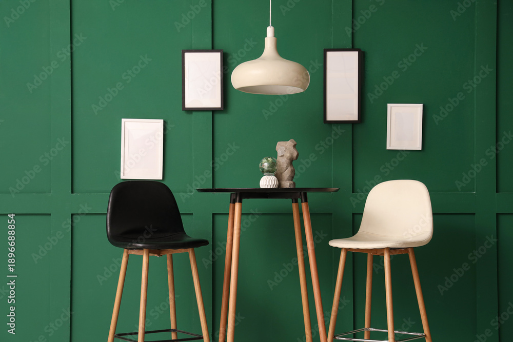 Fototapeta premium Interior of modern stylish room with chairs and table near green wall