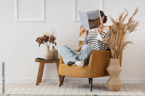 Young woman reading magazin...