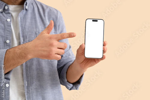 Young man pointing at mobil...