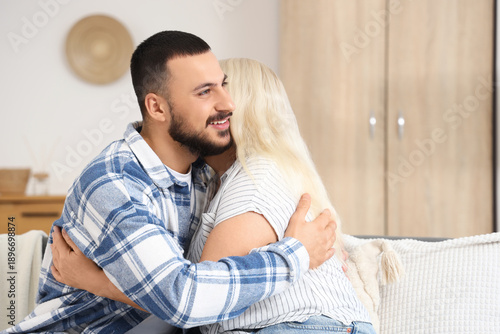 Happy young man hugging his...