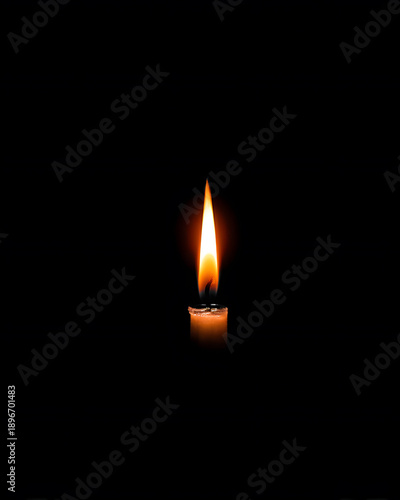 Candle burns brightly in a dark room during a quiet evening