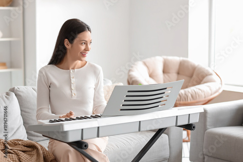 Young woman playing synthes...