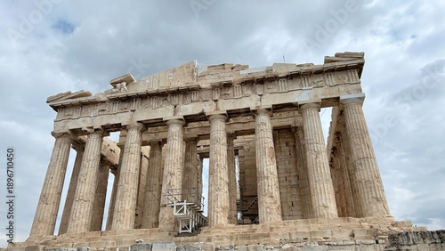 Iconic Parthenon temple on the Acropolis of Athens, showcasing ancient Greek architecture with tall Doric columns and marble structure. Dramatic cloudy sky enhances the historic monument.
