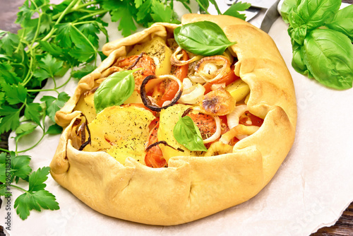 Galette of potato and tomato on dark board