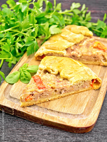 Galette with minced meat and peppers on black board