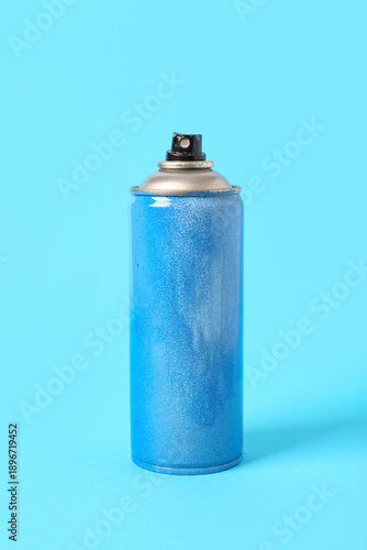 Spray paint can on blue bac...