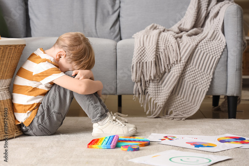 Stressed little boy sitting...
