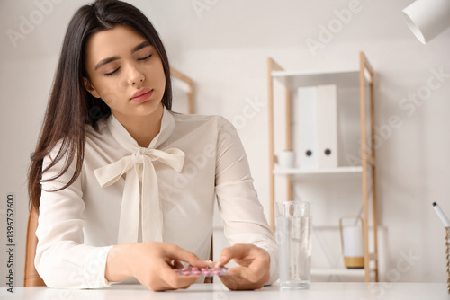 Sick woman with pills in of...
