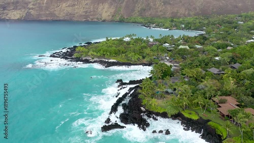 Aerial Drone Flight Over Luxury Oceanfront Estates and Lush Palm Trees, Powerful Waves Crashing on Volcanic Coast, Big Island Hawaii, 4K