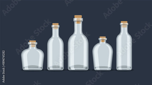 Set of five empty clear glass bottles of various shapes and sizes sealed with natural wooden cork stoppers.