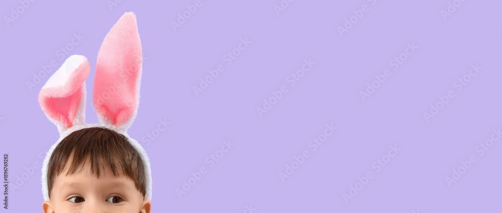 Fototapeta premium Cute little boy wearing Easter bunny ears on lilac background with space for text
