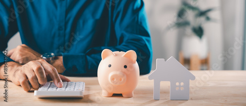 Photos Real estate money investment, piggy bank home saving, man uses calculator near s