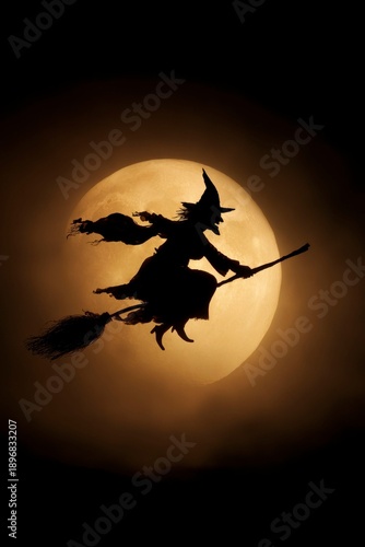 silhouette of a witch flying on a broom, with a full moon in the background