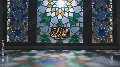 Sunlight through mosque stained glass window with Ramadan Kareem calligraphy