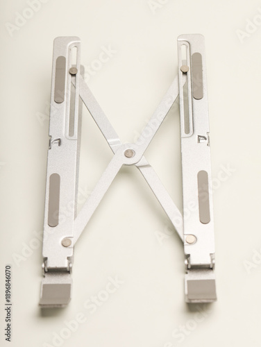 Silver metallic laptop stand, foldable and isolated on white background