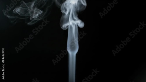 Wispy smoke rising against a dark backdrop, with curled formations