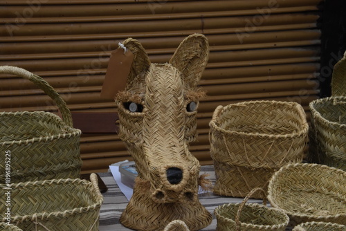 Handwoven Straw Animal Head Among Traditional Baskets