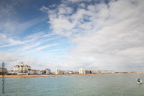 Coastal Town Seafront Under Dramatic Sky With Boats And Historic Buildings By The Shore