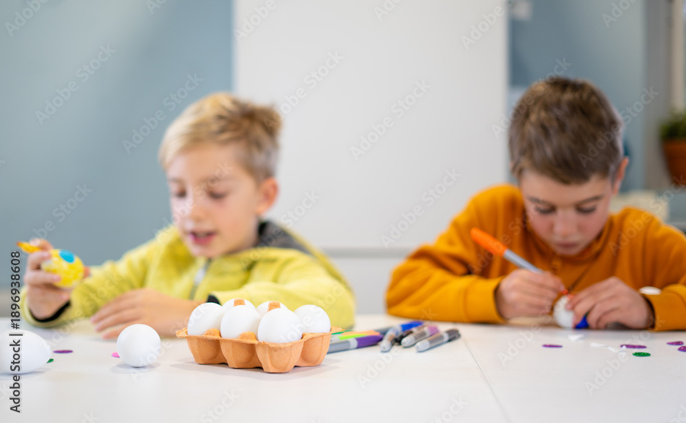 Naklejka premium Children decorating eggs for easter festivities at home