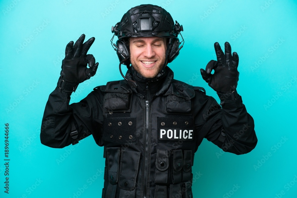 © luismolinero - SWAT caucasian man isolated on blue background in zen pose