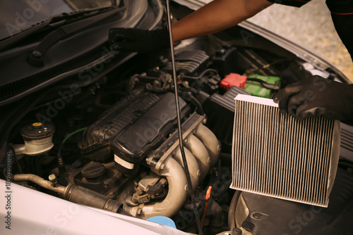 Obraz na plátně Auto mechanic holding car air conditioner filter for check and clean dirty or fix repair heat have engine problem or replace new change air filter of car care maintenance servicing concepts