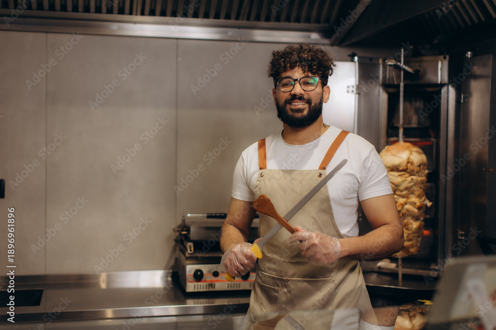Ταπετσαρία Male chef holding knife and spatula in shawarma restaurant
