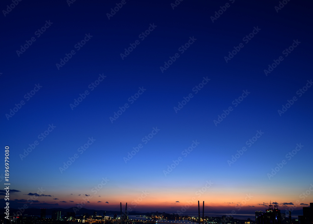Fototapeta premium City skyline at blue hour with cable-stayed bridges.