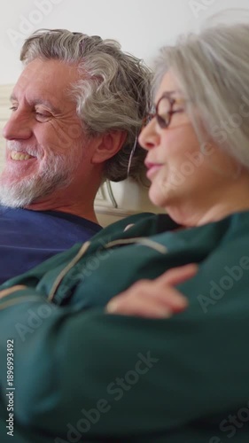 Elderly couple relaxing in bed with laptop