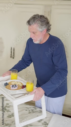 Mature husband bringing romantic breakfast in bed for his wife