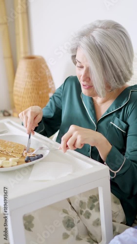 Senior mature couple eating breakfast in bed
