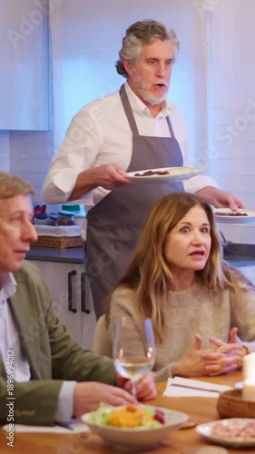 Senior man serving appetizers during friends dinner