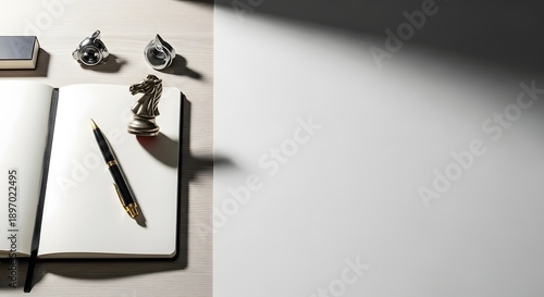 Desk workspace with open notebook, pen, and miniature sculpture on white background with sunlight