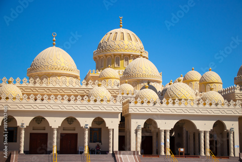 Great decorated islamic mosque called El Mina Masjid in town Hurghada, Egypt with lot of domes on the roof and two high towers.