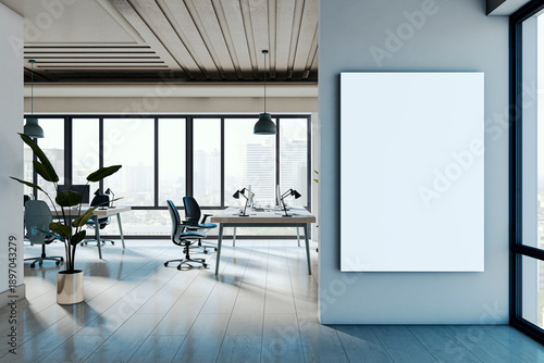 Vertical blank poster frame on modern office wall with clean interior and large windows overlooking city skyline in daylight setting. 3D Rendering