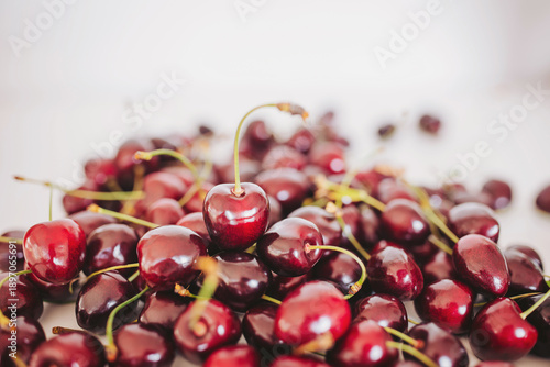 Foto A plethora of ripe, glossy cherries fills the countertop, their deep red color shining under serene sunlight