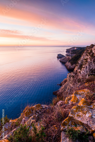Sunrise on the edge of the coastline cliff