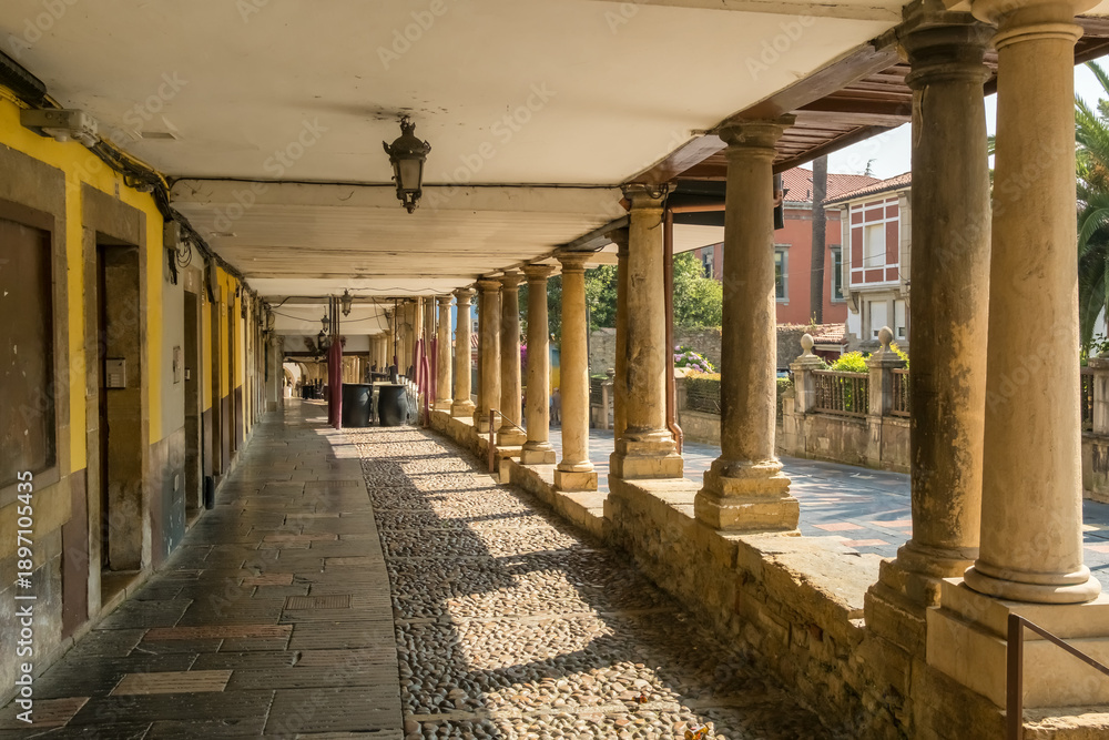 Obraz premium Historic Stone Columns and Cobblestone Pedestrian Passage in Aviles