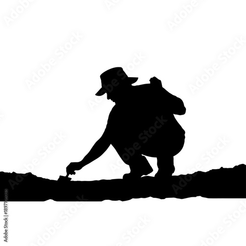 Silhouette of a person gardening, planting, or working outdoors.