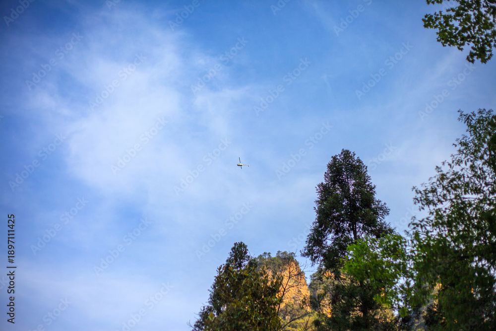 Fototapeta premium A blue sky with a white cloud and a small plane flying in the sky