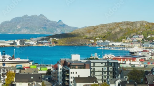 Bodo, Norway. View of the marina in the city center of Bodo, Norway with a fjord and a mountain in the background. Time-lapse during a sunny winter day, panning video