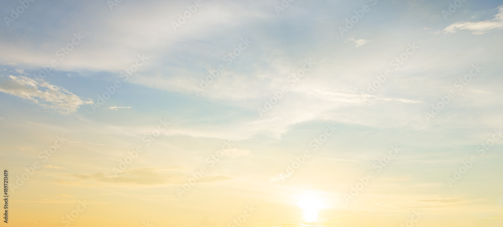 Obraz premium Beautiful sunset sky with soft orange and purple clouds background,Panoramic view of dramatic evening sky during sunset. Vibrant orange light on the horizon blending with soft purple and blue tones.