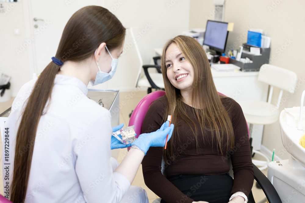 Obraz premium A dentist shows a woman how to brush her teeth
