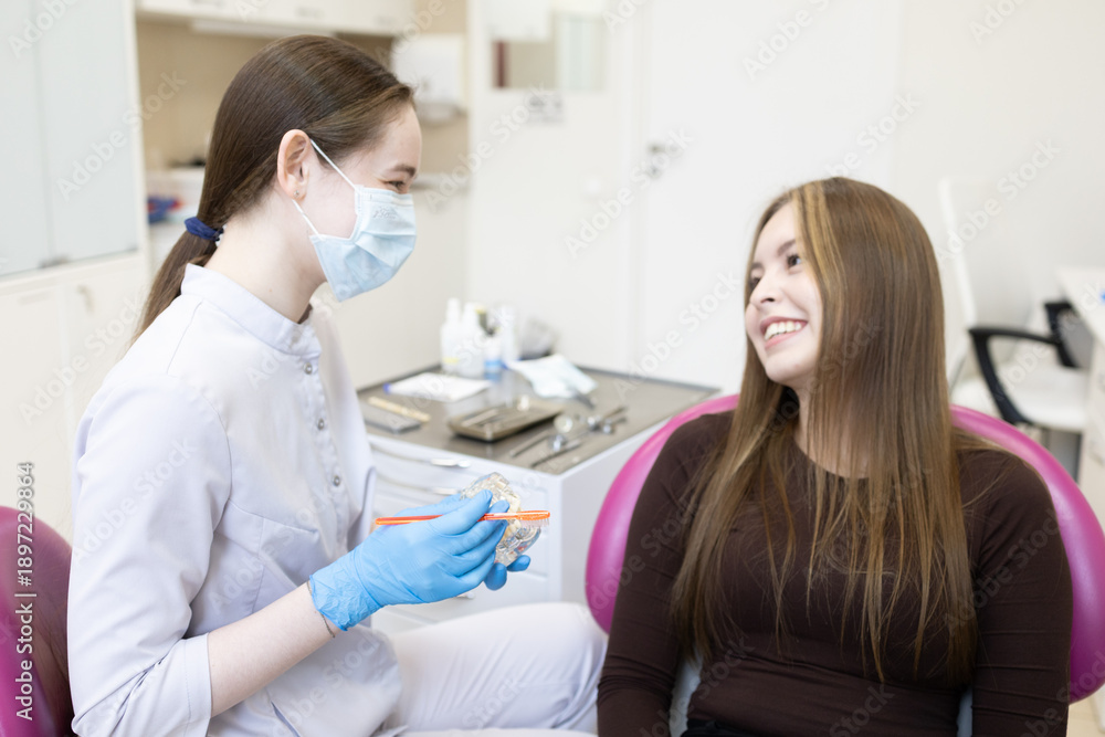 Obraz premium A dentist shows a woman how to brush her teeth