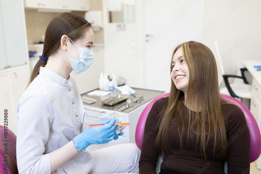 Obraz premium A dentist shows a woman how to brush her teeth