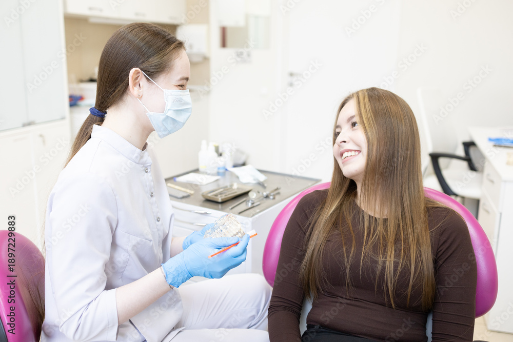 Fototapeta premium A dentist shows a woman how to brush her teeth